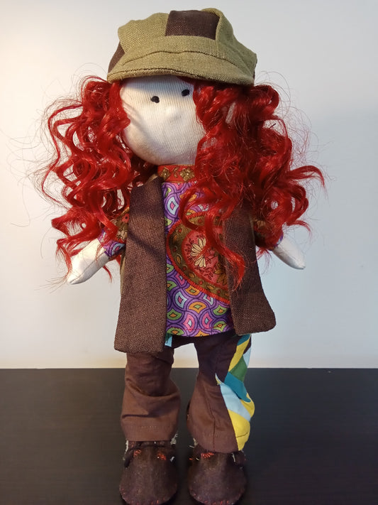 “Handmade collectible doll with red curly hair wearing a colorful boho outfit.”
