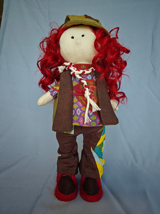 Doll with red hair, green cap, and colorful outfit on a light blue background